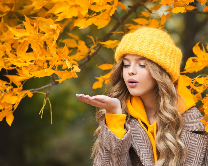 Beautiful girl walking outdoors in autumn. Smiling girl collects